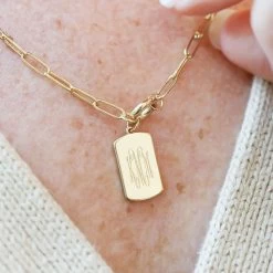 Monogrammed Tag Necklace -Fashion Clothing Store 8kO close up of monogrammed on tag necklace on neck