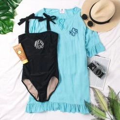 Monogrammed Cover Up -Fashion Clothing Store I1W ocean flatlay with black once piece and green palms