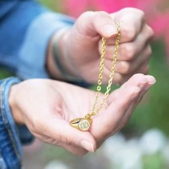 Monogrammed Signet Ring Necklace -Fashion Clothing Store K3k holding gold signet ring necklace