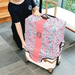 Monogrammed Luggage Cover -Fashion Clothing Store Lnk securing monogrammed coral floral luggage cover over checked suitecase