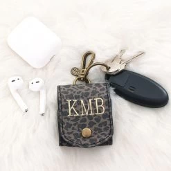 Monogrammed AirPod Case Keychain -Fashion Clothing Store T9S earbud keychain on fuzzy rug