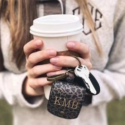 Monogrammed AirPod Case Keychain -Fashion Clothing Store T9S girl holding earbud keychain with coffee cup