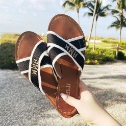 Monogrammed Criss Cross Sandal Set -Fashion Clothing Store h5C girl holding monogrammed criss cross sandals at the beach