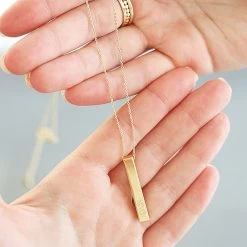 Personalized Bar Necklace -Fashion Clothing Store o7D gold personalized bar necklace in hands